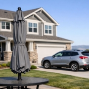 Stock photo of a Highlands Ranch, Colorado home and vehicle, with a closed umbrella symbolizing added liability protection, no people present.