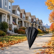 Autumn scene with well-kept Colorado rental homes and a closed umbrella on the walkway, illustrating insurance protection for property owners.